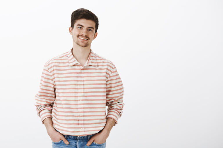 Pleasant friendly boyfriend meeting with parent. Portrait of good-looking confident man with moustache, holding hands in pockets and smiling broadly while talking with friends casually in bar.
