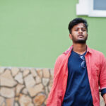 Portrait of young stylish indian man model pose in street.