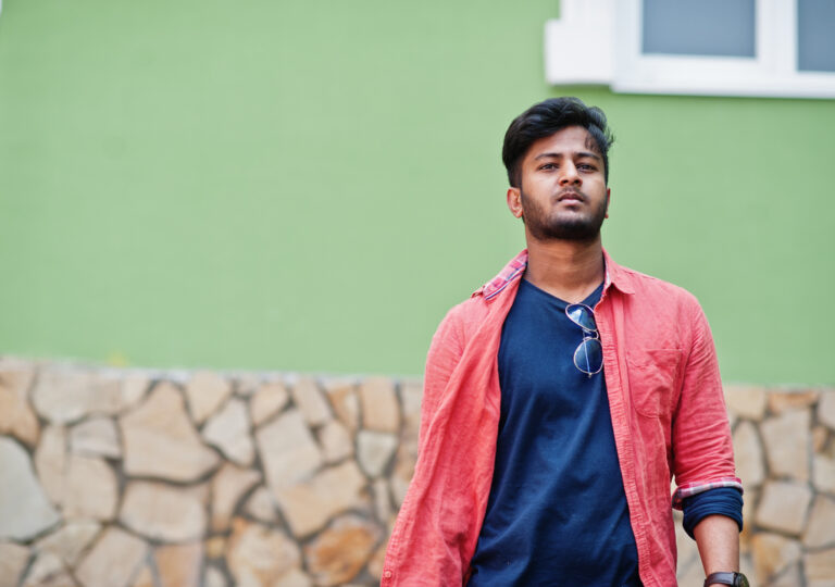 Portrait of young stylish indian man model pose in street.